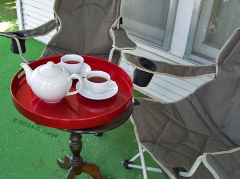 The green outdoor carpeting, red tray, and white teawares sort of gave our tea time a Christmas look, but temps were in the low 90s with high humidity! (Photo by A.C. Cargill, all rights reserved.)