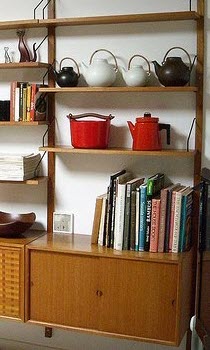 Mix it up by putting some teapots on a bookshelf along with some books. (stock image)
